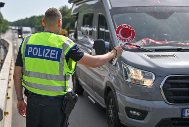 Ein Bundespolizist steht auf der Autobahn A12 nahe dem deutsch-polnischen Grenzübergang und stoppt ein Auto bei der Einreise nach Deutschland.