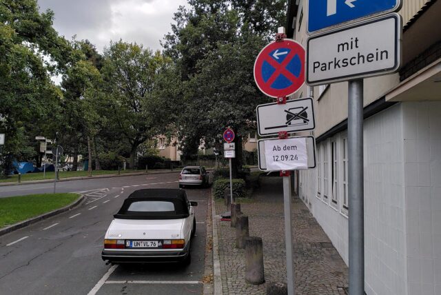 An einem Straßenrand in Unna parken Autos. Daneben stehen Schilder, die ein Halteverbot ankündigen.