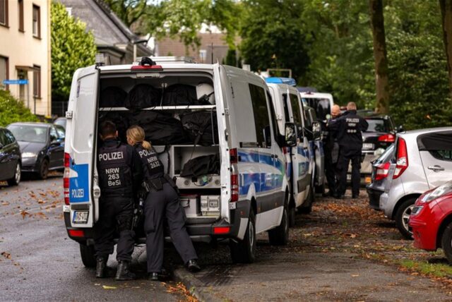 Polizisten stehen bei ihren Einsatzfahrzeugen in der Nähe einer Grünanlage. Knapp drei Wochen nach dem tödlichen Messerangriff in Solingen sucht die Polizei in der Stadt erneut nach Beweismitteln. «Wir bestätigen Suchmaßnahmen», sagte ein Düsseldorfer Polizeisprecher. Dabei seien Kräfte einer Hundertschaft mit einem Diensthund im Einsatz.