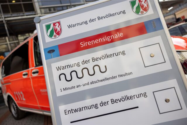 Auf einem Display vor der Leitstelle der Feuerwehr Düsseldorf sind die verschiedenen Sirenensignale zur Warnung der Bevölkerung abgebildet.