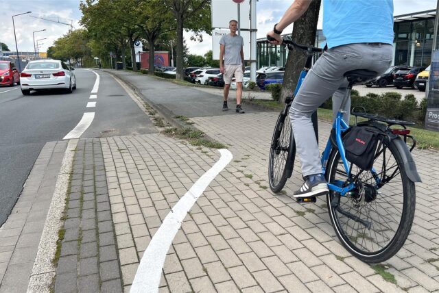 Ein Radfahrer fährt vom Radweg an der Hansastraße in Unna auf den Gehweg, den sich Fußgänger und Radfahrer seit kurzem teilen müssen.