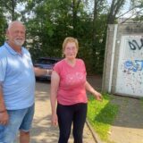 Uwe Görke-Gott von der SPD steht zusammen mit Anwohnerin Angela Stoffers am Parkplatz vor dem Kinderspielplatz an der Friedrich-Hegel-Straße in Schwerte-Holzen.