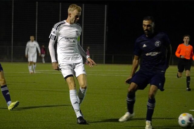 Bastian Ehrentraut (m.) umgeben von zwei Gegenspielern.