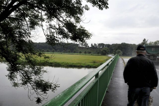 Ein Mann geht über die Ruhrbrücke am Wellenbad in Schwerte-Geisecke. Das Wetter ist trüb.
