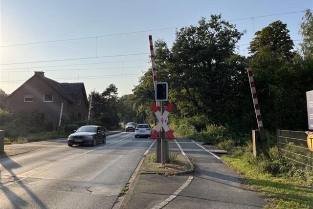 Autos fahren über den beschrankten Bahnübergang an der Lünener Straße.