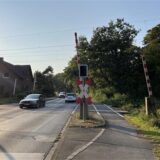 Autos fahren über den beschrankten Bahnübergang an der Lünener Straße.