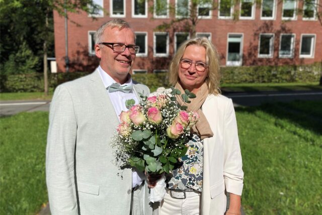 Angelika Rippel und Hans Twiehoff stehen nach ihrer standesamtlichen Trauung am Rathaus in Herten.