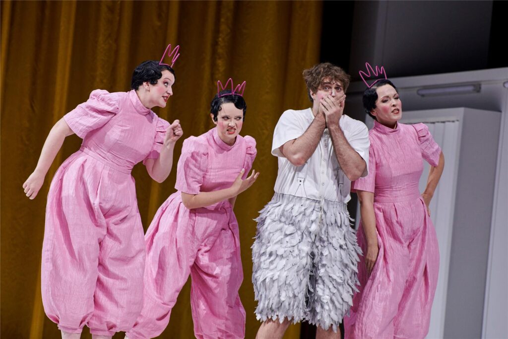 Papageno (Tobias Greenhalgh) in seiner Schweigeprüfung, umgeben von den drei Damen der Königin Papageno (Tobias Greenhalgh) in seiner Schweigeprüfung, umgeben von den drei Damen der Königin