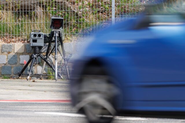 Ein Auto fährt an einem mobilen Blitzer vorbei.