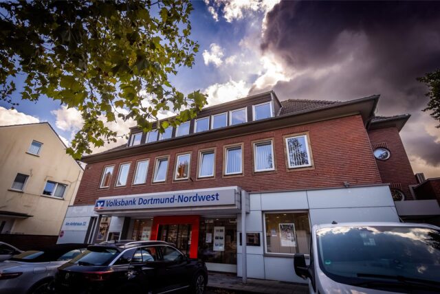 Dunkle Wolken sind über dem Hauptsitz der Volksbank Dortmund-Nordwest in Dortmund-Mengede zu sehen.