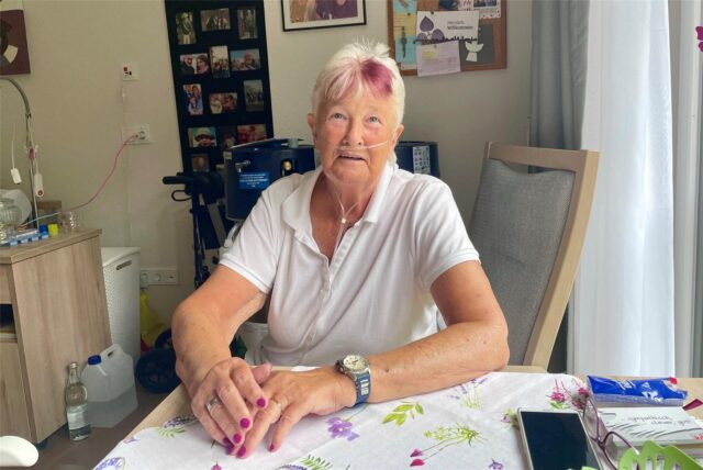 Uschi Pathmann sitzt in ihrem Zimmer im Pflegeheim in Herne an einem Tisch.