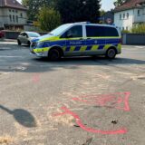 Auf einer Straße in Unna steht ein Polizeifahrzeug. Auf der Fahrbahn sind Markierungen, die einen Unfall dokumentieren.