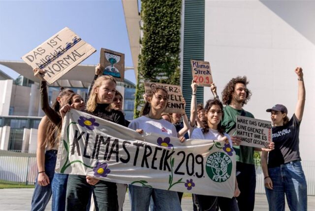 Mitglieder von Fridays for Future Deutschland halten vor dem Bundeskanzleramt bei einer Pressekonferenz zum geplanten globalen Klimastreik am 20. September 2024 ein Transparent mit der Aufschrift „Klimastreik 20.9.“