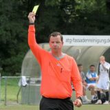 Schiedsrichter zeigt die Gelbe Karte.