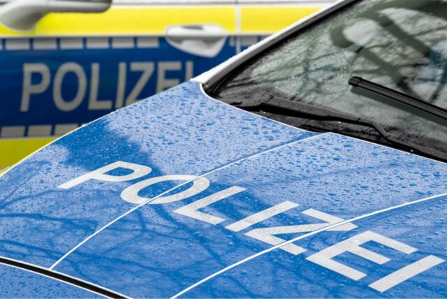 Der Schriftzug „Polizei“ steht auf der Kühlerhaube eines Autos.