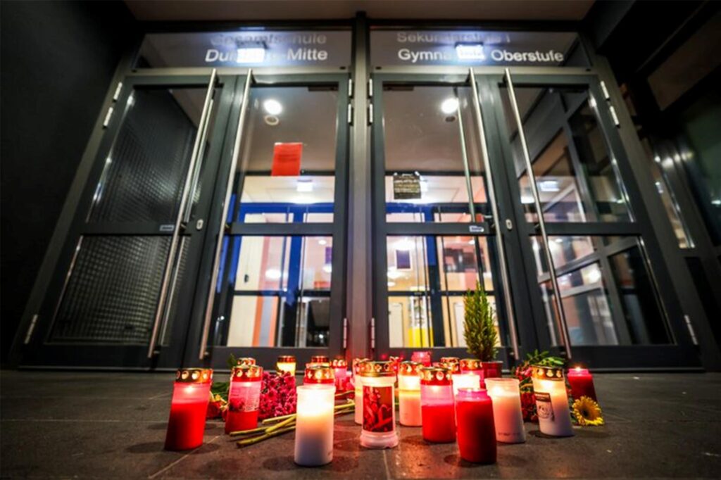 Kerzen stehen vor dem Eingang der Gesamtschule Duisburg-Mitte. Bei einem Verkehrsunfall an der Mittelmeerküste der Toskana sind zwei Schülerinnen der Schule ums Leben gekommen. Die beiden Teenager - Jahrgang 2005 und 2006 - wurden im Strandbad Lido di Camaiore vom Auto einer 44 Jahre alten Frau erfasst, die aus zunächst ungeklärten Gründen in eine Gruppe von Fußgängern fuhr. Kerzen stehen vor dem Eingang der Gesamtschule Duisburg-Mitte. Bei einem Verkehrsunfall an der Mittelmeerküste der Toskana sind zwei Schülerinnen der Schule ums Leben gekommen. Die beiden Teenager - Jahrgang 2005 und 2006 - wurden im Strandbad Lido di Camaiore vom Auto einer 44 Jahre alten Frau erfasst, die aus zunächst ungeklärten Gründen in eine Gruppe von Fußgängern fuhr.