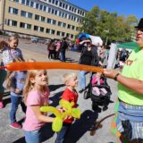 Ein Luftballon-Künstler im Wasserpark in Bergkamen bastelt Figuren aus Luftballons für mehrere Kinder, die um in herumstehen.