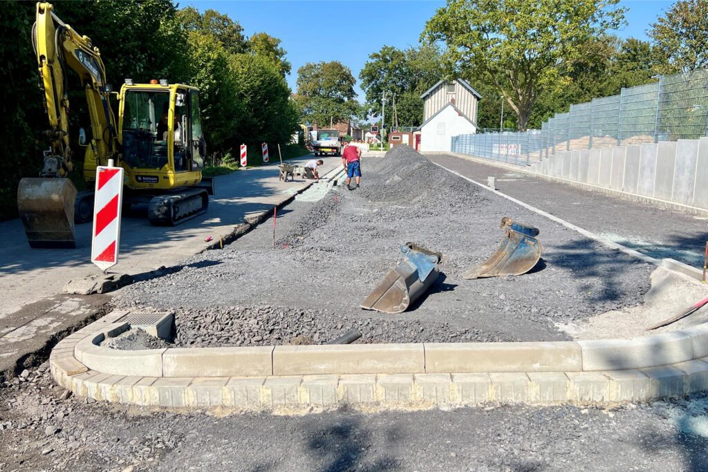 Am Bahnhof Unna-Lünern ist eine große Baustelle mit Bagger und Bauarbeitern zu sehen. Schotter liegt auf dem Boden, wo neue Parkplätze entstehen sollen. Am Bahnhof Unna-Lünern ist eine große Baustelle mit Bagger und Bauarbeitern zu sehen. Schotter liegt auf dem Boden, wo neue Parkplätze entstehen sollen.
