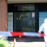 Absperrung der Polizei im Hintergrund das betroffene Geschäft, auf das geschossen wurde.