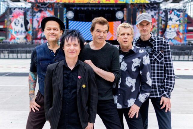 Campino (M, bürgerlich: Andreas Frege), Sänger der Punkband «Die Toten Hosen», Andreas von Holst (l, Kuddel), Michael Breitkopf (r, Breiti), Andreas Meurer (Andi) und Stephen George Ritchie (2.v.l. Vom Ritchie), stehen vor der Bühne im RheinEnergieStadion.