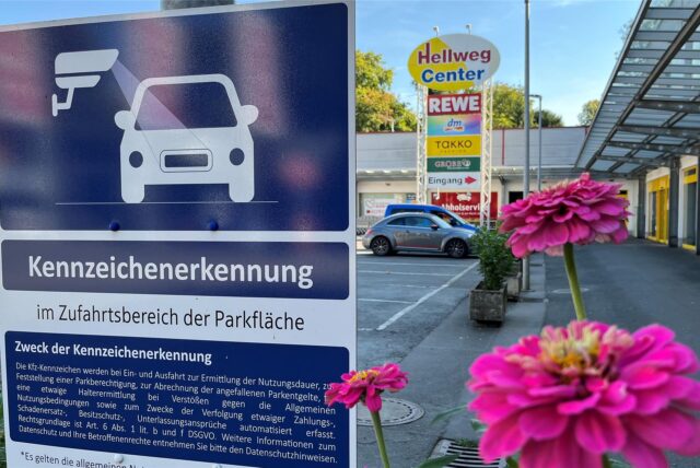 An der Zufahrt zum Parkplatz des Hellweg-Centers weisen große Schilder auf die Kameraerfassung bei der Einfahrt hin.