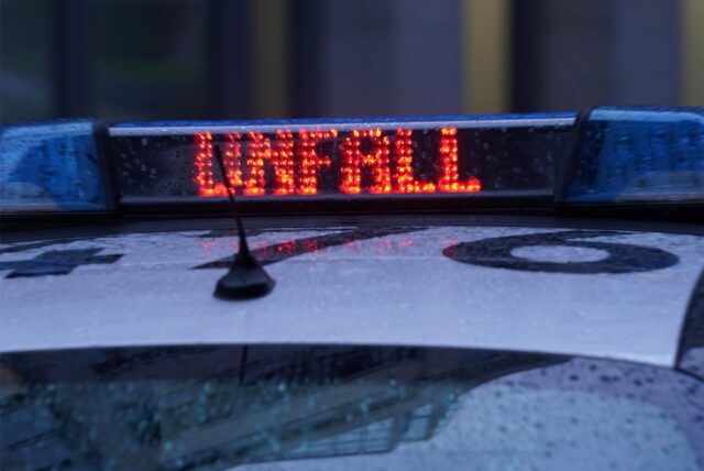 Auf einem Streifenwagen leuchtet das Wort „Unfall“ auf.