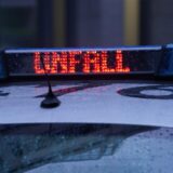 Auf einem Streifenwagen leuchtet das Wort „Unfall“ auf.