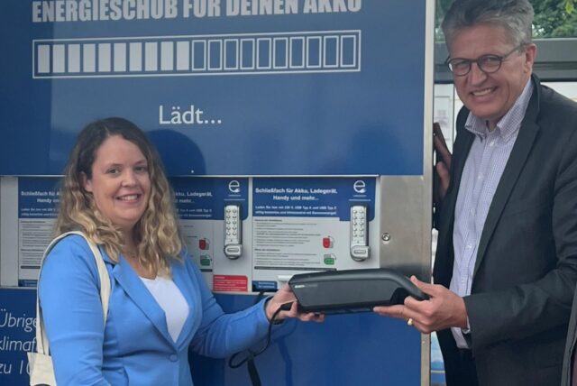 Mobilitätsmanagerin Carina Steffens und Bürgermeister Bernd Schäfer mit einem Akku an der neuen Ladestation.