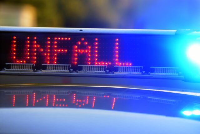 Auf einem Polizeiauto leuchtet die Anzeige „Unfall“.