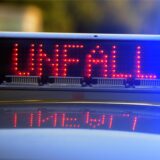 Auf einem Polizeiauto leuchtet die Anzeige „Unfall“.