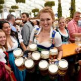 Eine Kellnerin hält mehrere Maßkrüge voller Bier.
