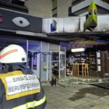 Der Einsatzleiter der Berufsfeuerwehr blickt auf die zerstörte Fassade der Ladenzeile mit Wohnhaus. Nach einer Explosion ist ein Café im Erdgeschoss eines Mehrfamilienhauses in Köln vollständig ausgebrannt.