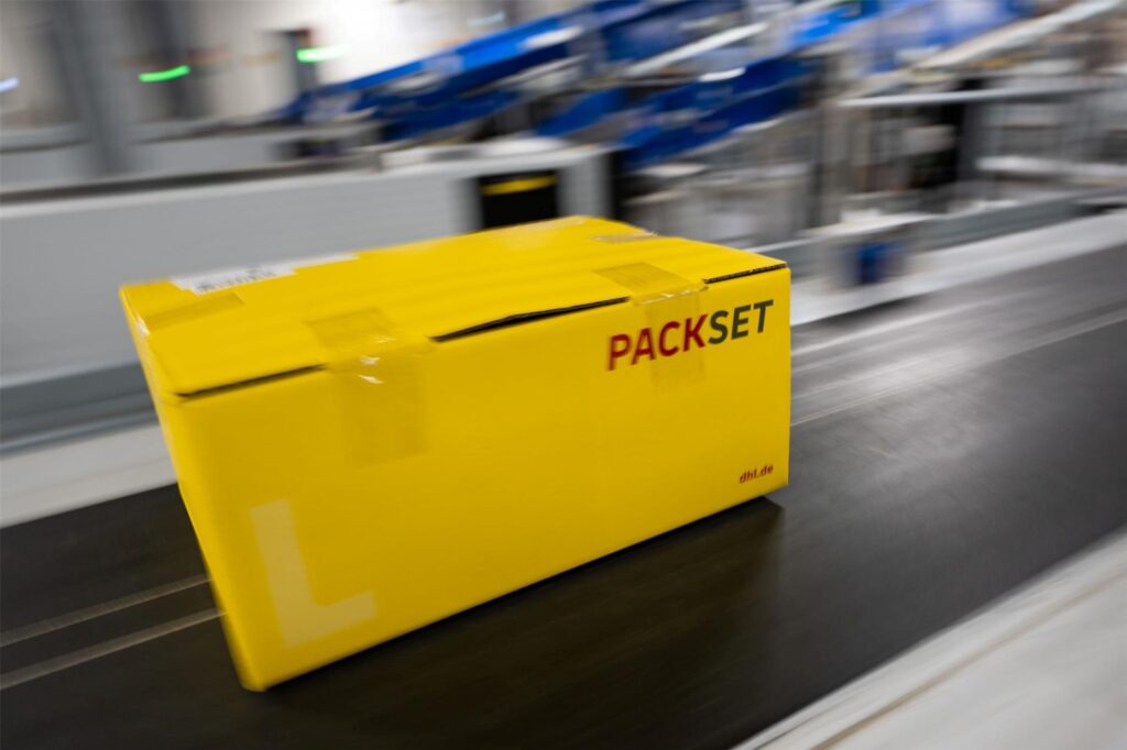 Ein Paket rollt über das Laufband eines DHL-Paketzentrums. Ein Paket rollt über das Laufband eines DHL-Paketzentrums.