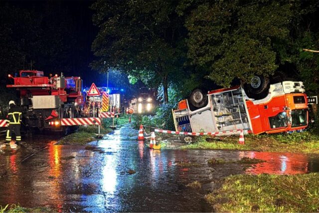 Feuerwehrleute und ein mobiler Kran arbeiten an einem verunfallten Tanklöschfahrzeug. Bei dem Unfall eines Feuerwehrautos im Landkreis Mettmann sind drei Feuerwehrleute verletzt worden.