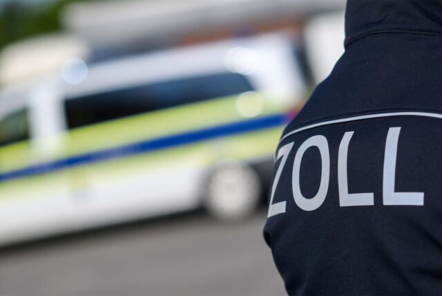 Zollbeamtinnen und -beamte stehen bei einer Kontrolle.