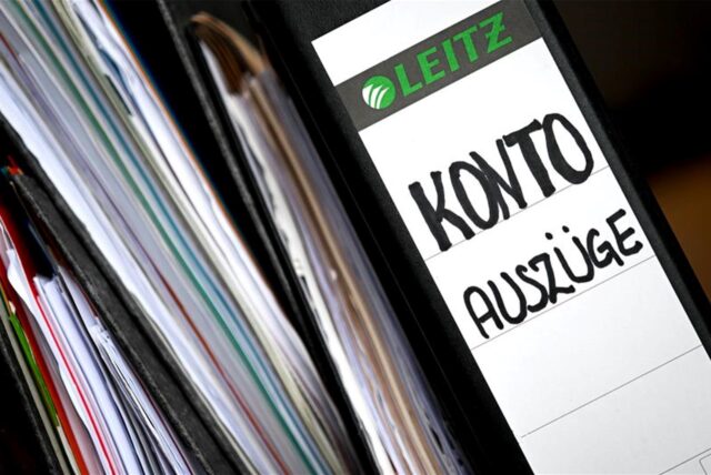 Aktenordner mit Kontoauszügen liegen auf einem Tisch.