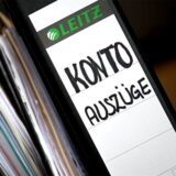 Aktenordner mit Kontoauszügen liegen auf einem Tisch.