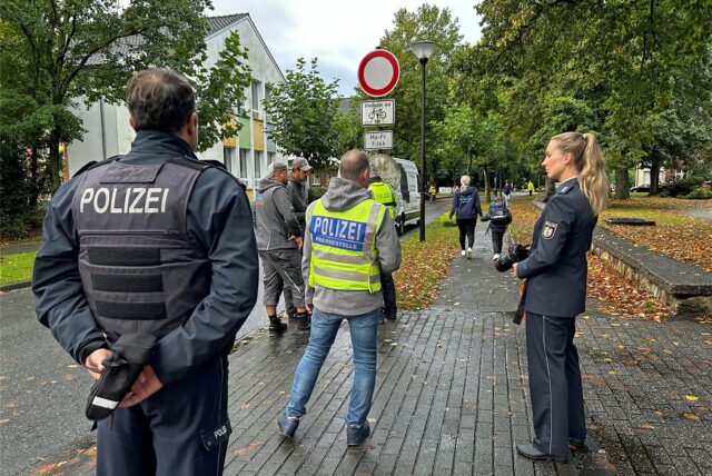 Zwei Herren (links im Bild) haben das Durchfahrt-verboten-Schild nicht gesehen. Die Polizeibeamten belehren sie über ihren Fehler.