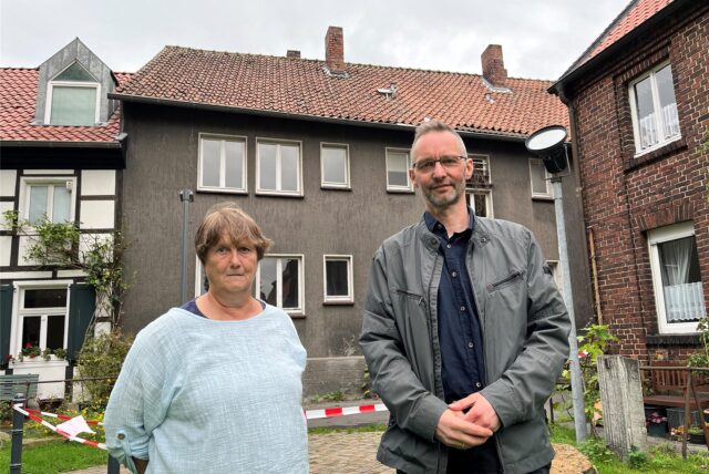 Martina Seeliger und Pfarrer Hanno Gerke weisen auf Gefahren hin, die von dem maroden Haus am Widumer Platz 7a ausgehen.