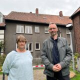 Martina Seeliger und Pfarrer Hanno Gerke weisen auf Gefahren hin, die von dem maroden Haus am Widumer Platz 7a ausgehen.