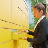 Eine Kundin verschickt ein Paket an einer Packstation.