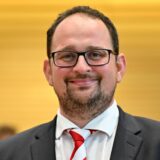 Thadäus König (CDU) sieht lächelnd in die Kamera.