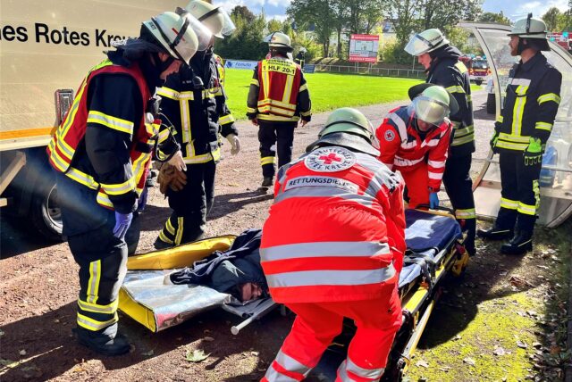 Einsatzkräfte von Polizei und Feuerwehr stehen bei einer Übung im Montanhydraulikstadion von Holzwickede am Samstag (28.9.) um eine scheinbar Verletzte herum.