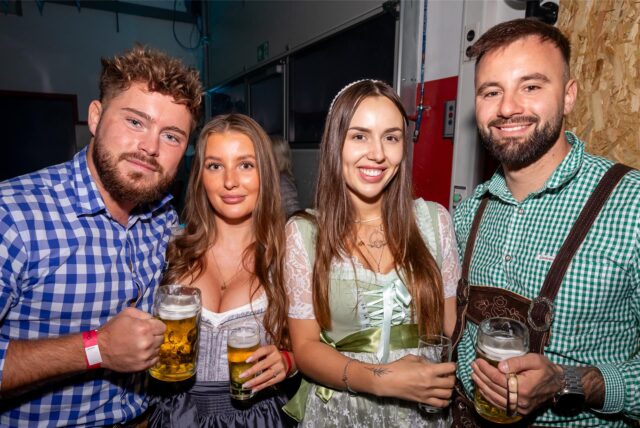 Vier Menschen prosten in die Kamera.