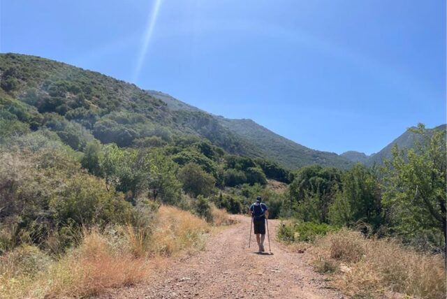 Ein Tourist geht bei wolkenlosem Himmel auf der griechischen Halbinsel Peloponnes wandern