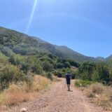 Ein Tourist geht bei wolkenlosem Himmel auf der griechischen Halbinsel Peloponnes wandern
