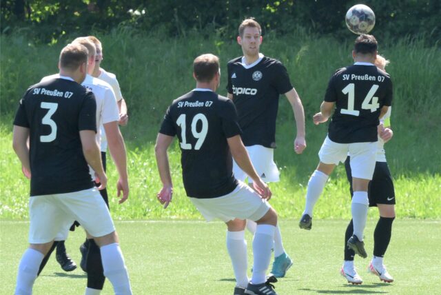 Mehrere Spieler schauen auf den Ball. Einer geht zum Kopfball.