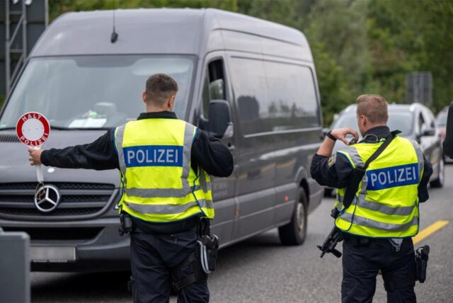 Ein Sprinter wird von zwei Polizisten zum Halten gebracht.