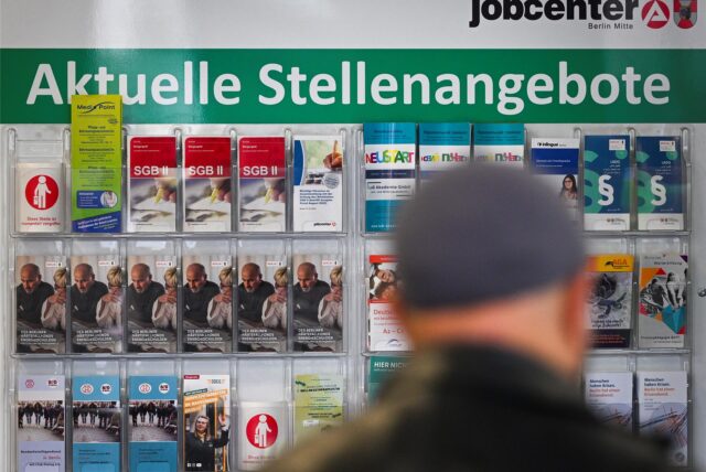 Flyer werden auf einer Tafel mit der Überschrift „Aktuelle Stellenangebote“ im Jobcenter Berlin-Mitte am Tag der Möglichkeiten angeboten.