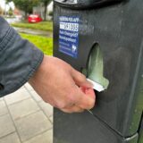 Eine Frau zieht einen Parkschein am Automaten.